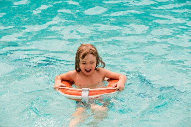 Çocuklar yazı. Havuz tatili. Aquapark 'taki mutlu çocuk. Çocuk suda yüzüyor. Havuzda etkinlikler