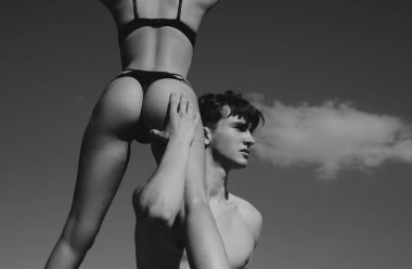 Sexy couple ejoy their beautiful fit bodies. Sensual naked couple in love. Handsome young man touching sexy ass of his slim fit hot girlfriend at blue sly background