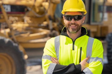 Kasklı bir inşaat işçisi. Yeni bina inşaatında çalışan bir işçi. İnşaat alanında çalışan bir inşaat işçisi. Foreman işçi portresi. Miğferli açık hava portresi. Sıkı şapkalı bir işçi