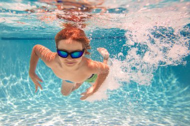 Havuzda yüzen bir çocuk. Komik küçük çocuk havuzda su altında yüzüyor. Suyun altındaki çocukların portresi. Yaz tatili. Çocuklar hafta sonu