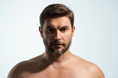 Kozmetik, vücut bakımı ve spa tedavisi. Beyaz arka planda izole edilmiş erkeksi, çekici, üstsüz bir adam portresi. Çekici adamın yakın plan portresi.