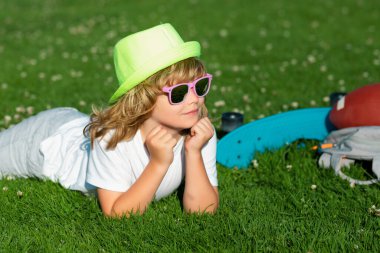 Çocuklar bahar parkında dışarıda oynuyorlar. Özgürlük ve tasasız. Yaz rüyası. Çocuk çimenlerde rüya görüyor. Çocukluk rüyası. Hayalperest çocuk. Hayaller ve hayal gücü. Rüya gibi çocuklar.