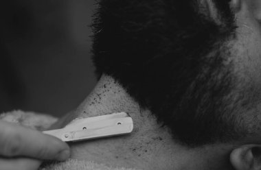 Tıraş sonrası erkekler. Tıraş losyonu kozmetik ürünü. Erkekler ciltlenir. Berber makası ve düz jilet. Tıraş sonrası kanlı deri