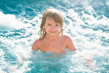 Tatlı çocuk havuzda yüzüyor. Aktif sağlıklı çocuklar için yaşam tarzı, su sporları aktiviteleri ve çocuklarla yaz tatili dersleri.