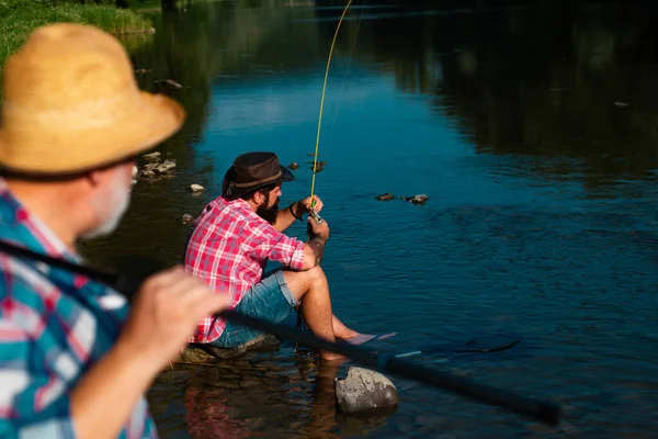 年轻的老渔夫拿着钓竿站在湖边 父亲和儿子享受生活 男人的家人 爷爷和Drandson钓鱼 成年渔夫庆祝退休 — 图库照片