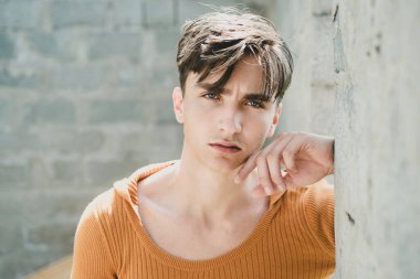 Gri duvara karşı şık bir genç adam.