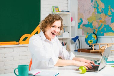 Heyecanlı komik kadın dizüstü bilgisayar kullanıyor, okulda ya da üniversitede öğretmenlik yapıyor. Mutlu kadın öğrenci öğretir ve öğrenir. Eğitim ve öğretim kavramı