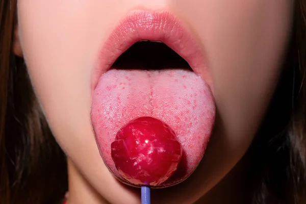 女人嘴里放棒棒糖 红色口红 女人舔一个红色闪亮的棒棒糖 靠近点性感的女人 性感的嘴上有棒棒糖 — 图库照片