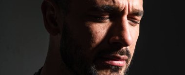 Yakından ağlayan adam. Ağlayan adamın kapalı gözlerinde yaşlar