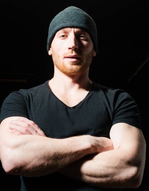 Çapraz kollu yakışıklı bir adam. Erkeklik gay, kendine güvenen erkek model