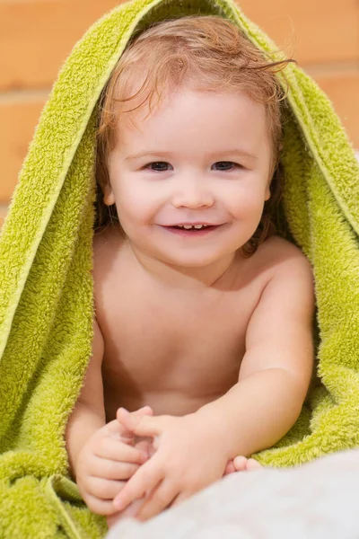 洗完澡后用毛巾把一个金发小男孩的画像贴在身上 有趣的婴儿在家里的床上洗澡后 — 图库照片