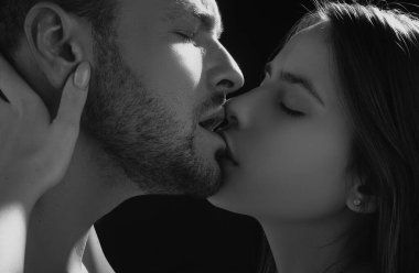 Şehvetli bir öpücük. Güzel, tutkulu, seksi çiftin öpüştüğü yakın çekim. Aşıkların öpücüklerinin güzel sanat portresi. Yaramaz ve tutkulu. Genç karı koca