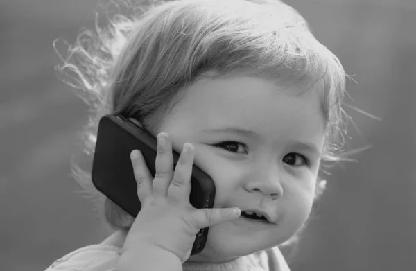 可爱的小宝宝在绿草上亲密接触 有趣的小孩肖像画 带着手机 带着智能手机 快乐童年 — 图库照片
