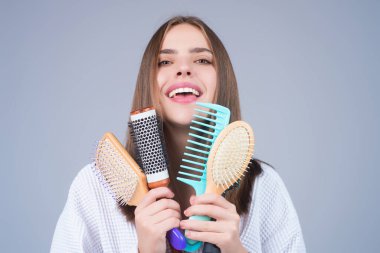 Saçını tarayan bir kadın. Sağlıklı ve temiz saçlara önem verir. Güzellik kuaförü konsepti. Stüdyoda taraklı bir kız. Taranmış saçlar, yumuşak yumuşak ipeksi saçlar keratin etkisi yapar. Saç fırçası