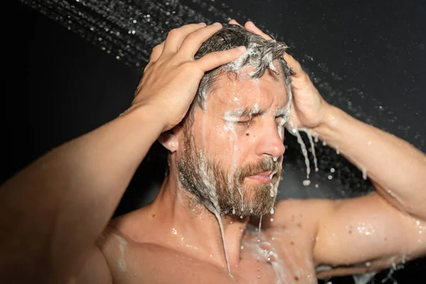 男は風呂で髪を洗う バスタブの中で男の入浴シャワーヘッド シャワーで泡に顔 入浴男がシャワーを浴びて シャワーを浴びてる男を閉めろ シャワーコンセプト 男はシャワーを浴びている — ストック写真