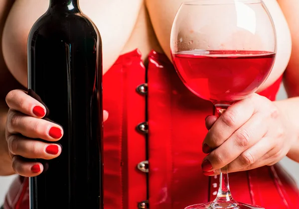 おっぱいの間のブラジャーの赤ワイン 女性プラスサイズのワインのガラスでポーズ Xxl大きなサイズ 美しい女の子は彼女の豪華な胸を示しています レストランメニューのワインリスト 赤ワイングラスを持つ女性 — ストック写真