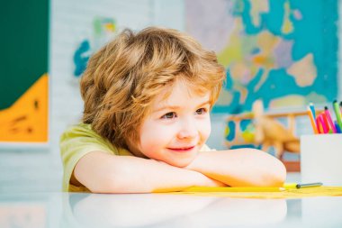 Derste mutlu okul çocukları. Çocuk okula hazırlanıyor. Komik yüzlü, sevimli bir öğrenci. Eğitimsel süreç. Güzel gözbebeği yüzü. Yakından.