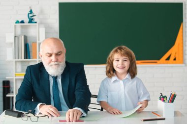 Okuldaki mutlu çocuk. Öğretmenin öğrenmesine yardım et. Eğitim, öğretmenlik, ilkokul