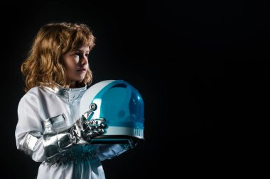 Uzay kıyafetli küçük astronot çocuk elinde siyah kaskla