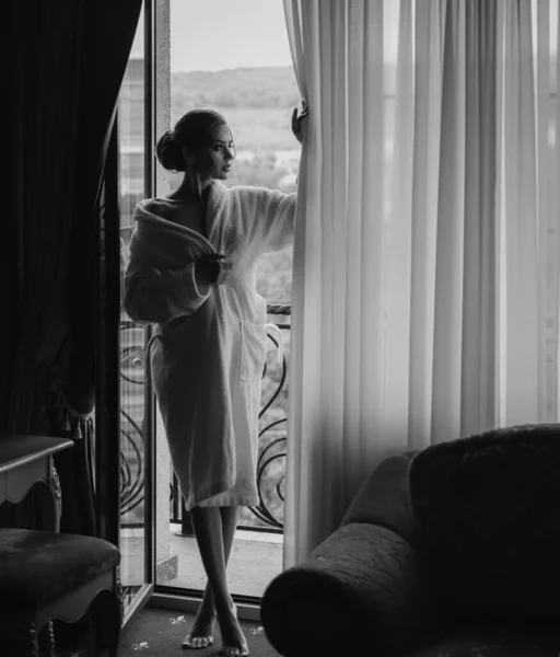 女人在早上 迷人的性感女人站在她家窗边 享受着一个完美舒适的早晨 — 图库照片