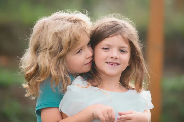 夏の庭で2人の小さな子供が抱き合ってキスをします 子供たちは恋に落ちる 友情と子供時代 — ストック写真