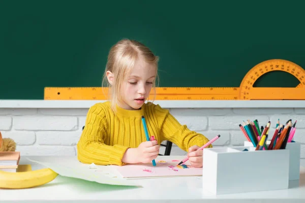 学校に戻る 机の上に可愛い生徒の女の子が描かれている 天才児 知識の日 子供の教育と知識 背景に黒板のある教室の子供 小学生の少女 — ストック写真