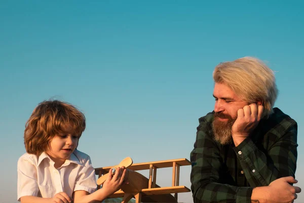 Two generations of men father and son have fun and playing with toy airplane. Family relationship with son. Love daddy