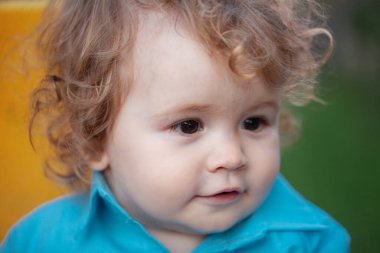 Küçük sarışın bir erkek bebeğin yakın portresi. Komik çocuk suratı