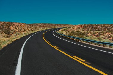 Amerikan yol gezisi. Sonbaharda mavi gökyüzü ile birlikte asfalt yol boyunca dümdüz ilerler.