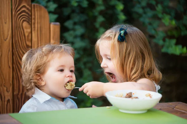 妹が赤ん坊に餌をやる かわいい面白い赤ちゃんが食べる 赤ちゃんの食べ物 健康的な子供の朝食 食欲あり — ストック写真