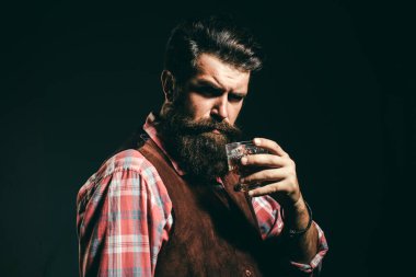 Sommelier adam. Takım elbiseli sakallı ve bıyıklı hipster, iş gününden sonra alkol içer. Loft viski cam ile siyah takım elbiseli kendinden emin sakallı adam