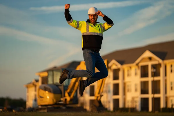 跳兴奋的工人 建筑工人在建筑工地 戴头盔的施工经理 男性建筑工程师 建筑师在一个建筑工地 戴着硬礼帽的杂工建筑工人 — 图库照片
