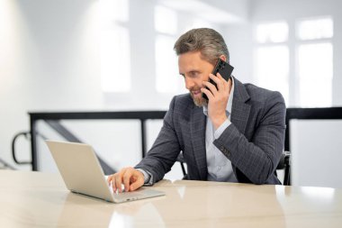 İçişleri Bakanlığı. İş adamı ofiste telefonda sohbet ediyor. Takım elbiseli bir iş adamı telefonu kullanıyor. Ofis çalışanı telefonda davaları çözer. Ofis müdürü konuşma telefonu. Yönetim kurulu başkanı akıllı telefon kullanıyor