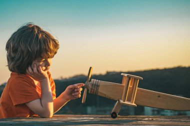 Çocuklar seyahat hayali kurar. Tatlı çocuk suratı. Kırsal kesimde yaz. Çocuk geleceğin hayalini kuruyor. Çocuk pilot rüya görüyor. Çocukluk hayali konsepti. Sarışın, tatlı hayalperest çocuk uçarken rüya görüyor. Hayaller ve hayal gücü