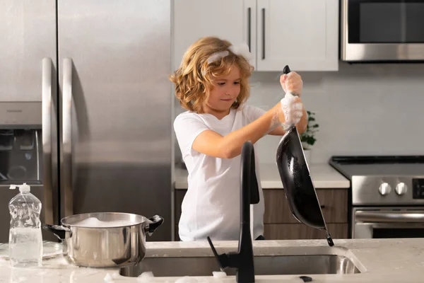 台所で食器洗いを手伝っている面白い双子の男の子 家事を楽しんでいる子供たち 台所の洗面台で皿を洗う子供の男の子 — ストック写真