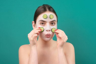 Güzellik tedavileri. Yüz maskesi. Cilt bakımı. Yüzünde salatalık dilimleri olan bir kadın.