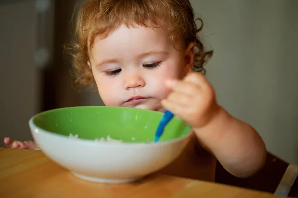 有趣的婴儿在厨房用勺子自己吃东西 儿童的健康营养 — 图库照片