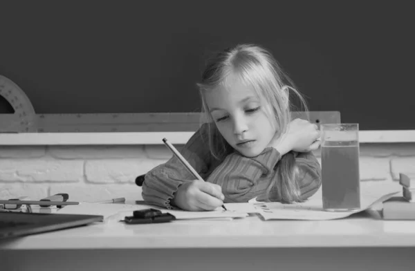 教室を背景にクラスメートと本の中で書くかわいい女の子の肖像画 学校で勉強する女の子 — ストック写真