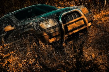 Offroad vehicle coming out of a mud hole hazard. Drag racing car burns rubber. Extreme. Off-road vehicle goes on the mountain. Motion the wheels tires and off-road that goes in the dust on the sand
