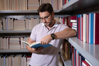 Kütüphanede kitap okuyan İspanyol bir öğretmen. Öğretmenler günü, öğretmenler günü. Öğretmenler günü. Öğretmenim okulda. Orta yaşlı öğretmenle bilgi ve eğitim. Kitaplı öğretmenler