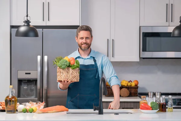 キッチンの自宅で新鮮な自然減量の食事を準備魅力的な男の肖像画屋内 台所で食事を準備するハンサムな陽気な男 健康食品 料理のコンセプト — ストック写真
