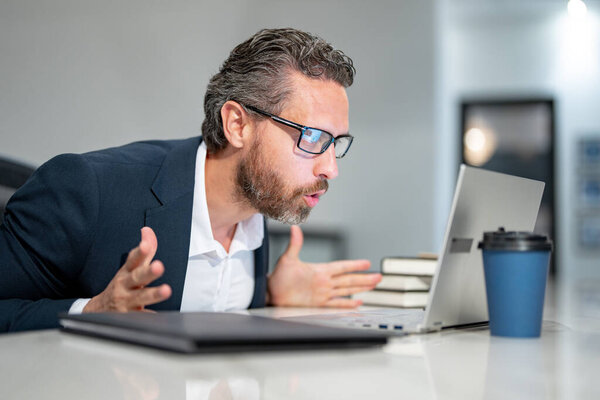 Modern office. Surprised caucasian business man in business suit using laptop, working remotely, e-commerce online at office. Finance auditor. Ceo manager employee having business idea. Business