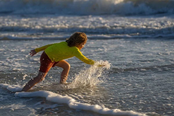 夏の海で水遊びをしている幸せな子供 夏休みだ 海で波の子供の遊び 海で遊んで水をこぼす小さな子供 子供は海でスプラッシュ水を再生します 夏休み — ストック写真