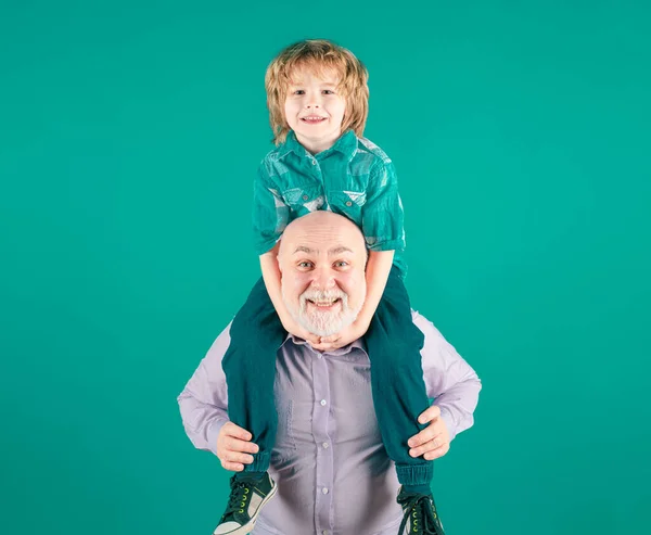 爷爷和孙子的背骑 脸上挂着滑稽的表情 在演播室里与蓝色隔离 — 图库照片