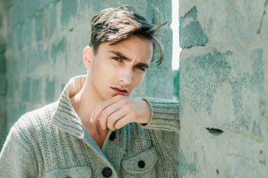 Genç adam kameraya bakıyor. Dışarıdaki yakışıklı adam.