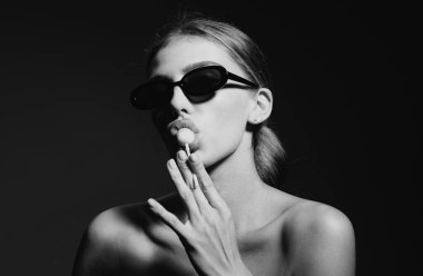 Seksi kadın yüzü. Şehvetli genç bir kadın stüdyo arka planında lolipop yalıyor. Güzellik, moda. Kozmetik, makyaj