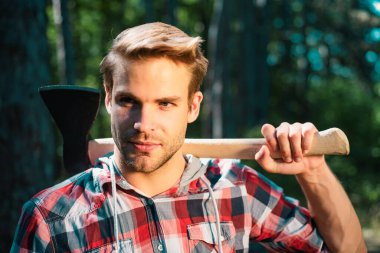 Ciddi yüzünde Lumberjack omuz balta taşır - portre kadar yakın. Elinde baltaolan oduncu. Sıkı çalışmadan sonra dinlenme