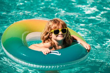 Aquapark Çocukları yaz tatilindeki çocuk. Havuzdaki çocuk. Şişirilebilir lastik çemberdeki mutlu çocuk.
