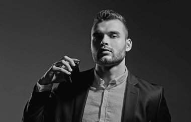 Parfüm lüzfünü. Bir şişe parfümeri tutan adam. Mans parfüm konsepti. Erkekparfüm