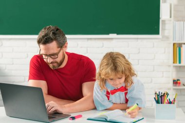 Sınıfta öğretmeni olan bir öğrenci. İlkokul çocuğu derste sınıfta. Öğretmenin öğrenciye açıklaması